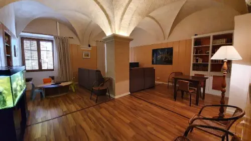 Salón con techos en arcos y luz indirecta de estilo rústico, con juegos para niños y equipo multimedia y biblioteca